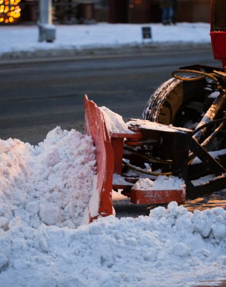 Tractor cleaning the road from the snow. Excavator cleans the streets of large amounts of snow in